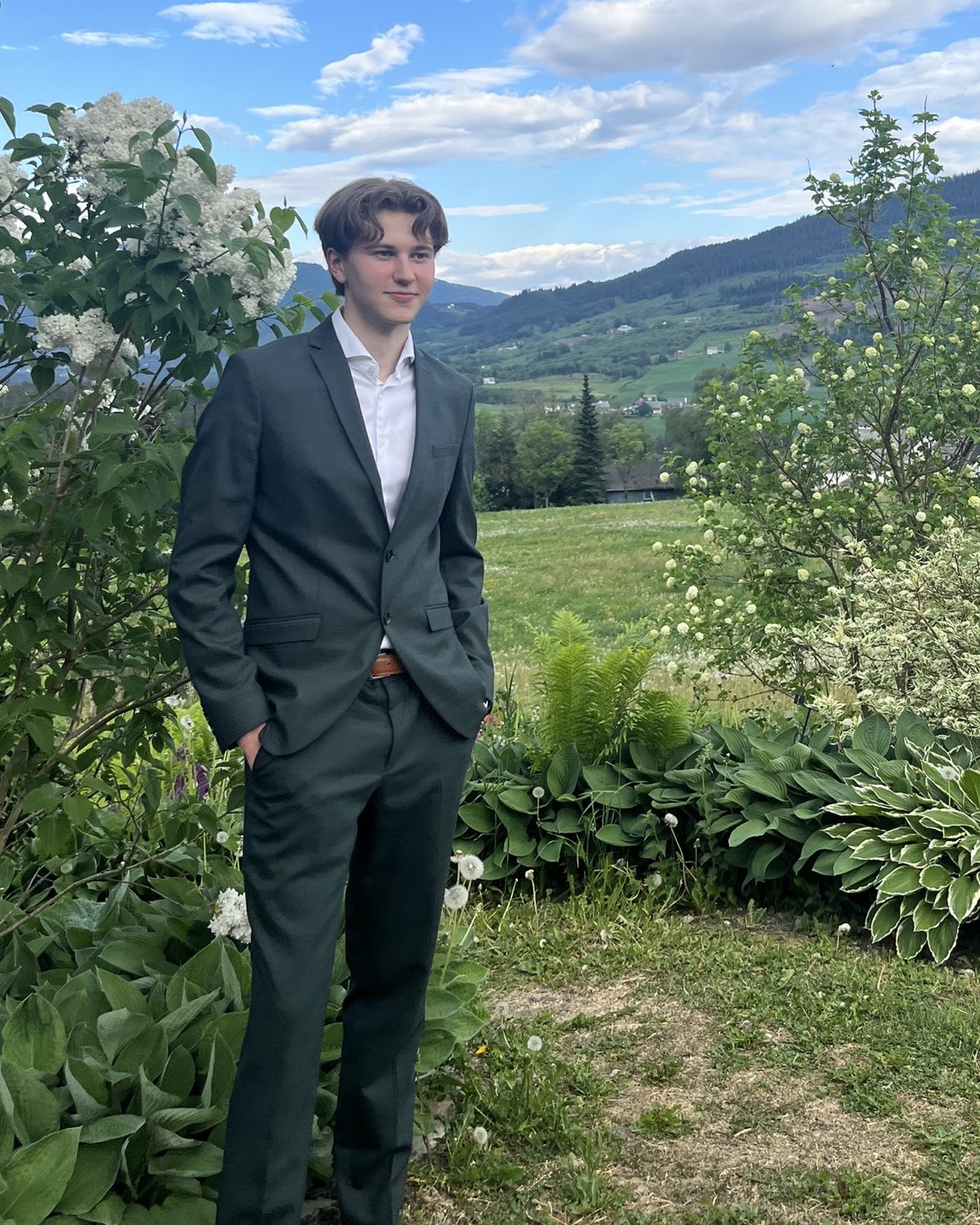 Kris Joakim, photographed outdoors above a green valley.